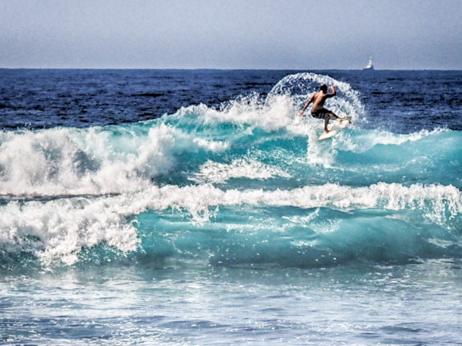 You can not take surfing pictures with a macro lens.